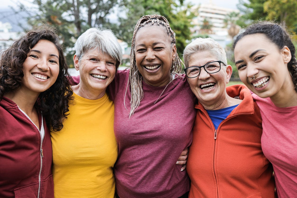 five smiling women taking a group photo